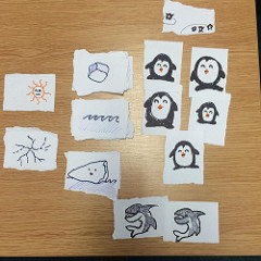 paper cards with drawings of penguins, sharks, ice, snow, waves