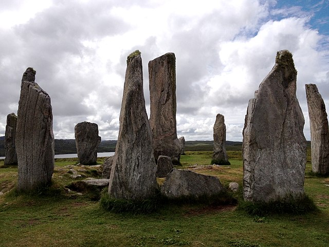 circle of tall weathered stones on a lush hilly landscape