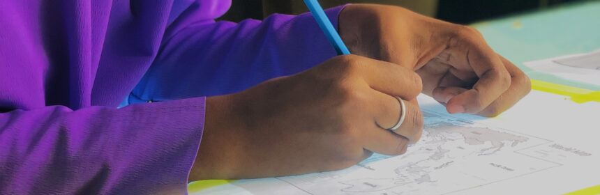 Student drawing a map using translucent paper