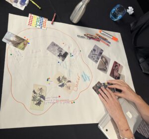 Colourful cards with images spread across white paper. The paper has notes written in crayon and colourful stickers next to the images.