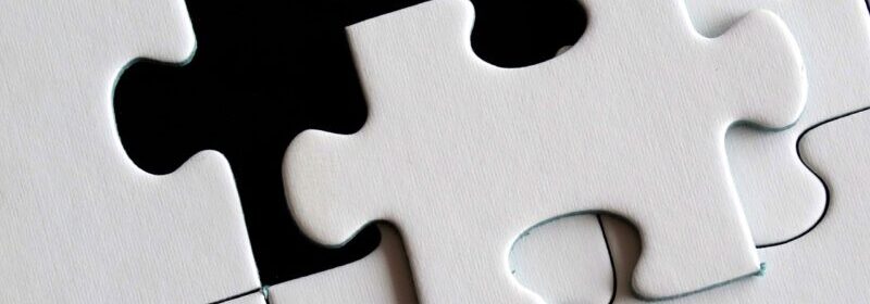 White puzzle with last piece being put in place.